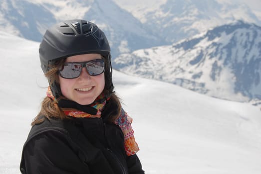 Young woman in winter sports clothes - mountains in the background