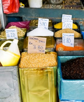 A variety of colorful spices in tin containers at a market in asia