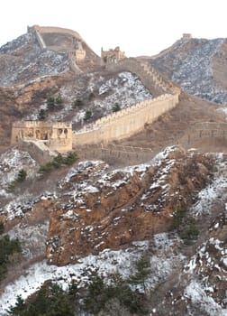 Distant view of the great wall of china with snow on the mountain
