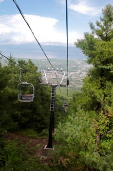 A chairlift going up a mountain pass in summer