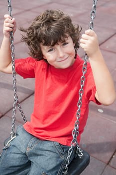 Happy child on the swing with red shirt