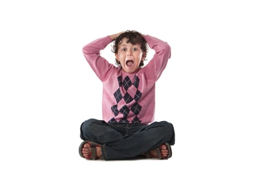 Surprised child sitting on a over white background