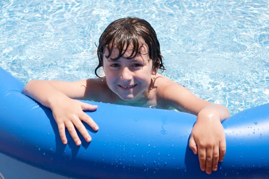Adorable little boy swiming in the swimming-pool