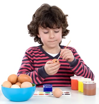 Child adorable adorning Easter eggs on a white background