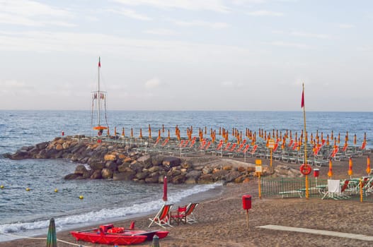 Shore beach with sun umbrella and deckchairs