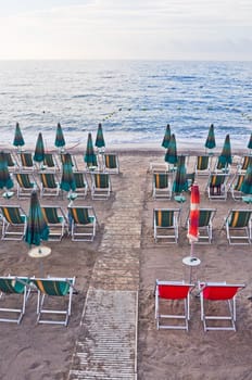 Shore beach with sun umbrella and deckchairs