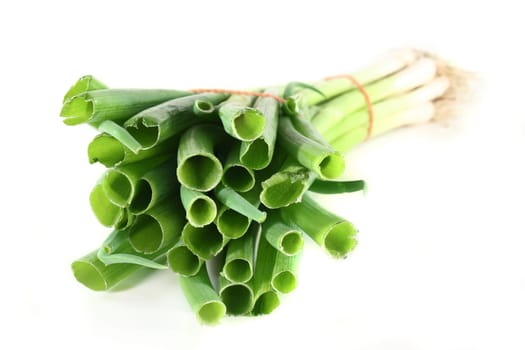 a bunch of spring onions against a white background