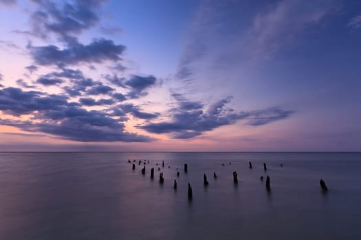 a scene with calm sea under sky with clouds