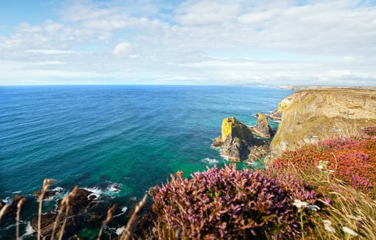 Landscape from Cornwall. Ocean or sea with cliffs and heather. Scenic and tranquil view of the coastline by Hells Mouth
