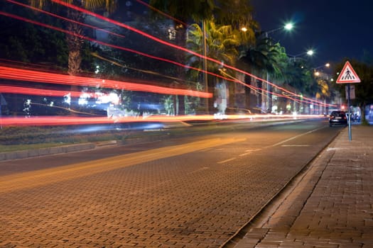 Night road, traces from red headlights of the cars