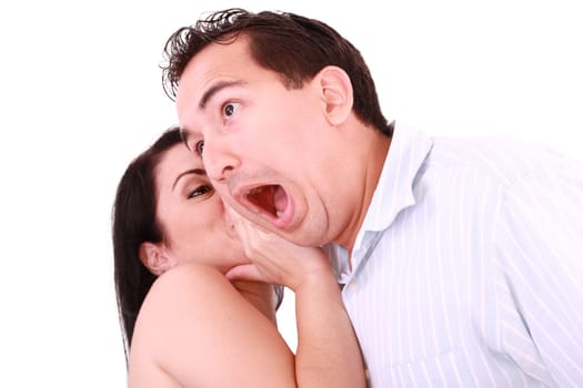 woman tells something into surprised guy&#039 s ear isolated on white background