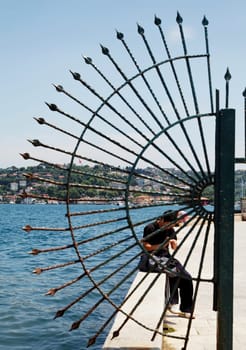 creative shot of Istanbul fishermans wharf and quayside through crescent railings, portrait, crop space