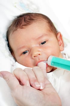 little boy drinking milk from the mother of the syringe