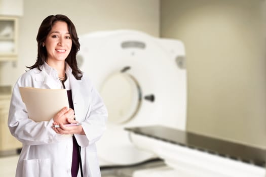 Beautiful happy female doctor physician radiologist holding patient medical chart and pen standing in CT CAT Scan room at hospital, isolated.