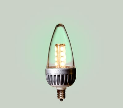 Illuminated LED bulb set against green ecological background with paths of main components included