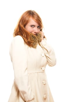 A young red-haired woman in beige winter coat against a white background