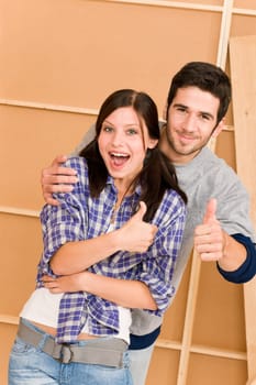 Home improvement young couple having fun new house thumb up