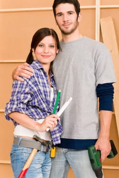 Home improvement young happy couple with repair tool hand drill ruler