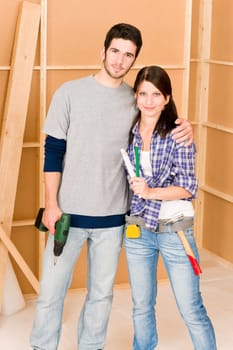 Home improvement young happy couple with repair tool hand drill ruler