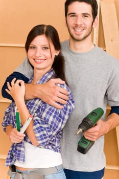 Home improvement young happy couple with repair tool hand drill ruler