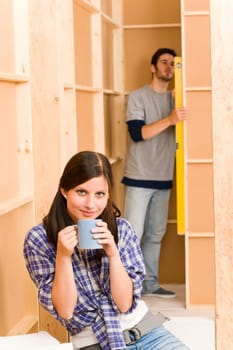 Home improvement smiling young couple fixing wall with water level