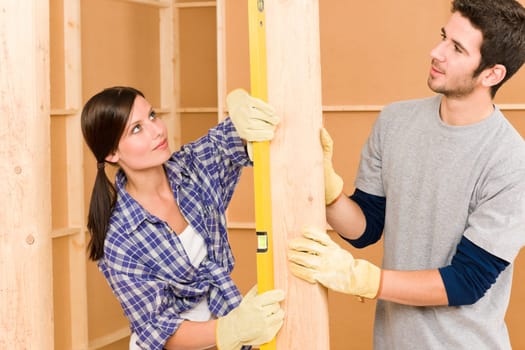 Home improvement smiling young couple fixing wall with spirit level