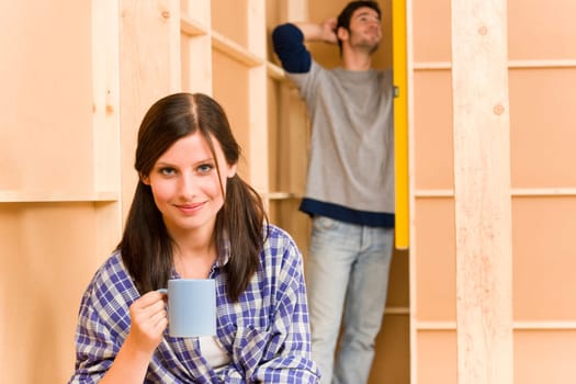 Home improvement smiling young couple fixing wall with water level