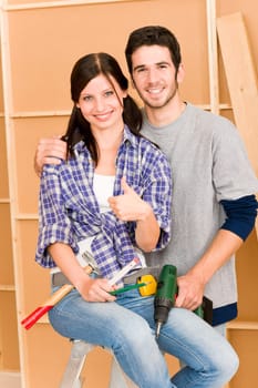 DIY home improvement young happy couple with hand drill ruler