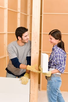 Home improvement smiling young couple building new brick panel wall
