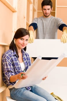 Home improvement happy young couple with architectural blueprints fixing house