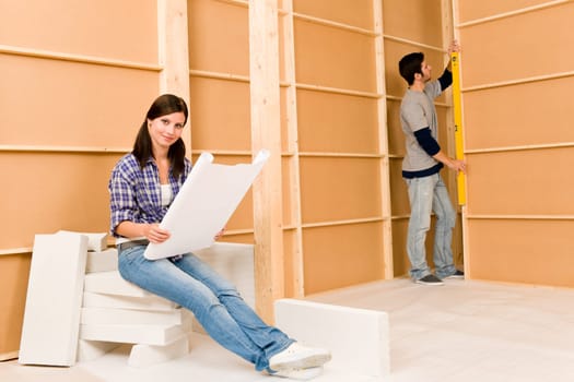 Home improvement happy young couple with architectural blueprints fixing house