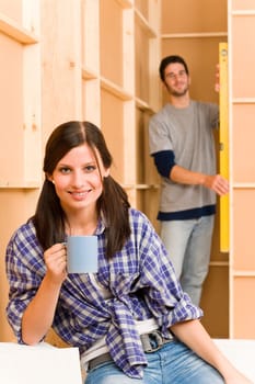 Home improvement smiling young couple fixing wall with water level