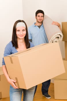 Happy couple with boxes and carpet moving into new home