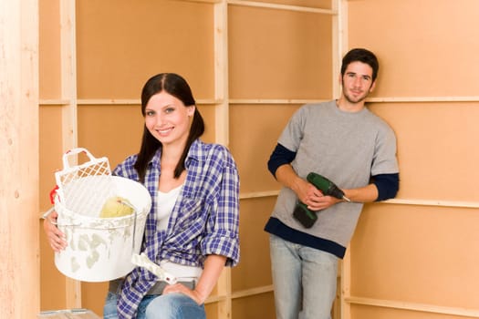 Home improvement: young happy couple fixing new house renovating wall