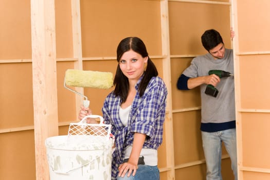 Home improvement: young happy couple fixing new house renovating wall