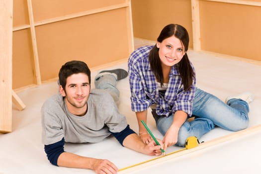 Home improvement young happy couple working on floor renovations