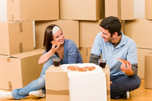 Moving into new home young happy couple eating pizza