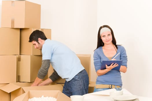 Moving new home young happy couple unpacking cardboard boxes together