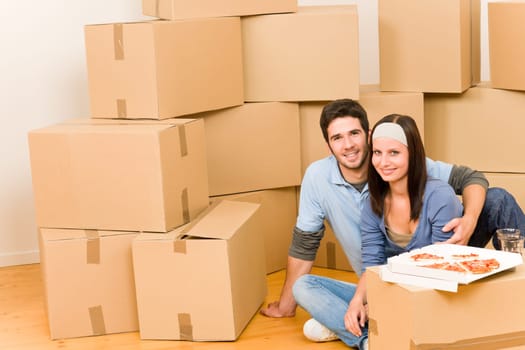 Moving into new home young happy couple eating pizza