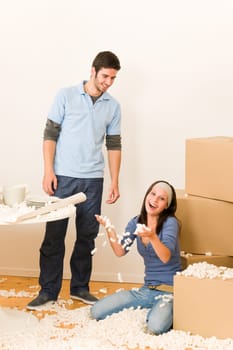 Moving new home young cheerful couple unpacking cardboard boxes together