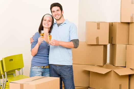 Moving into new home young happy couple celebrating toast Champagne