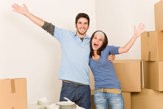 Moving new home young cheerful couple unpacking cardboard boxes together