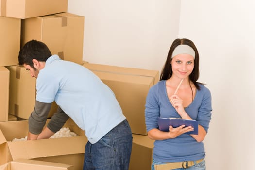 Moving new home young happy couple unpacking cardboard boxes together