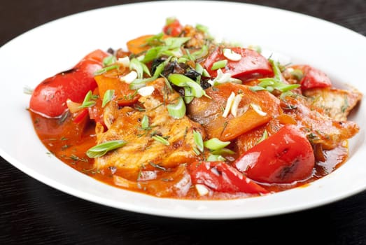 pork meat with tomato, pepper, prunes, garlic and green onion