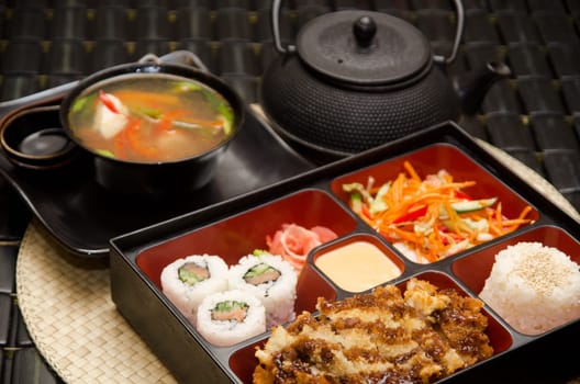 Sushi lunch with soup salad tea and sauce