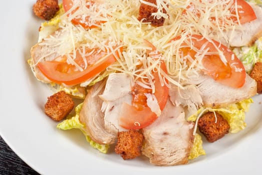 Salad of lettuce, chinese cabbage, tomato, garlic rusk, parmesan cheese, sauce and chicken meat