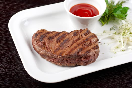Juicy roasted beef steak with vegetables closeup at plate