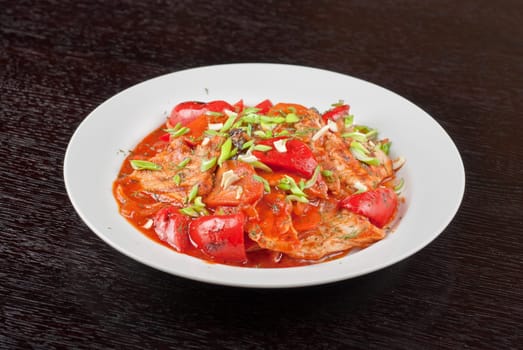 pork meat with tomato, pepper, prunes, garlic and green onion