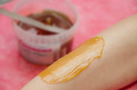 Sugaring: epilation with liquate sugar at legs.