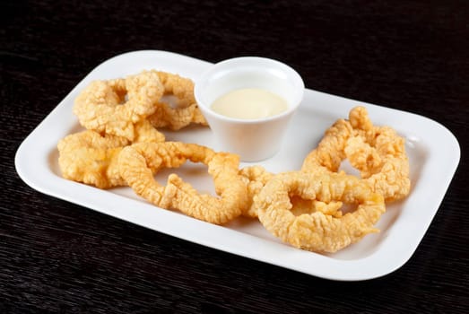 Deep-fried squid with sauce at white plate